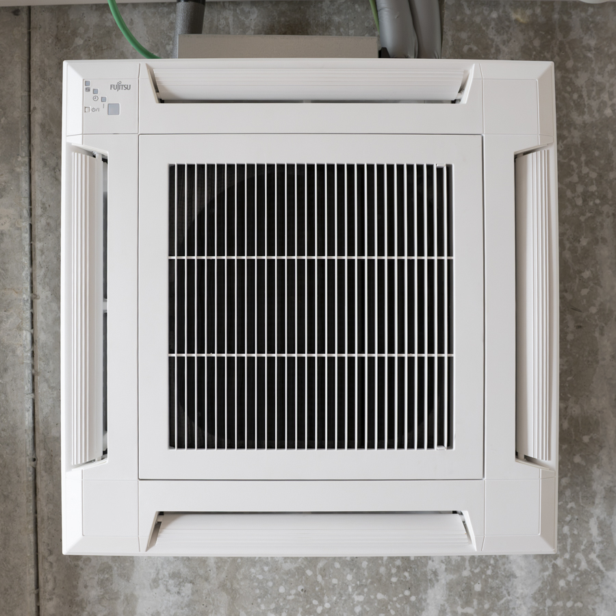 Onderaanzicht van een airco unit aan het plafond bij fietsenwinkel Soupape