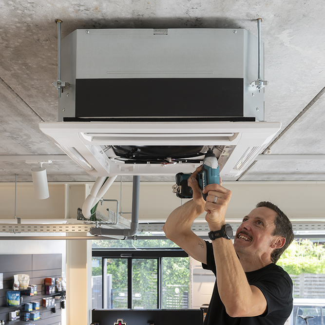 Fabrice is bezig met een airco onderhoud.